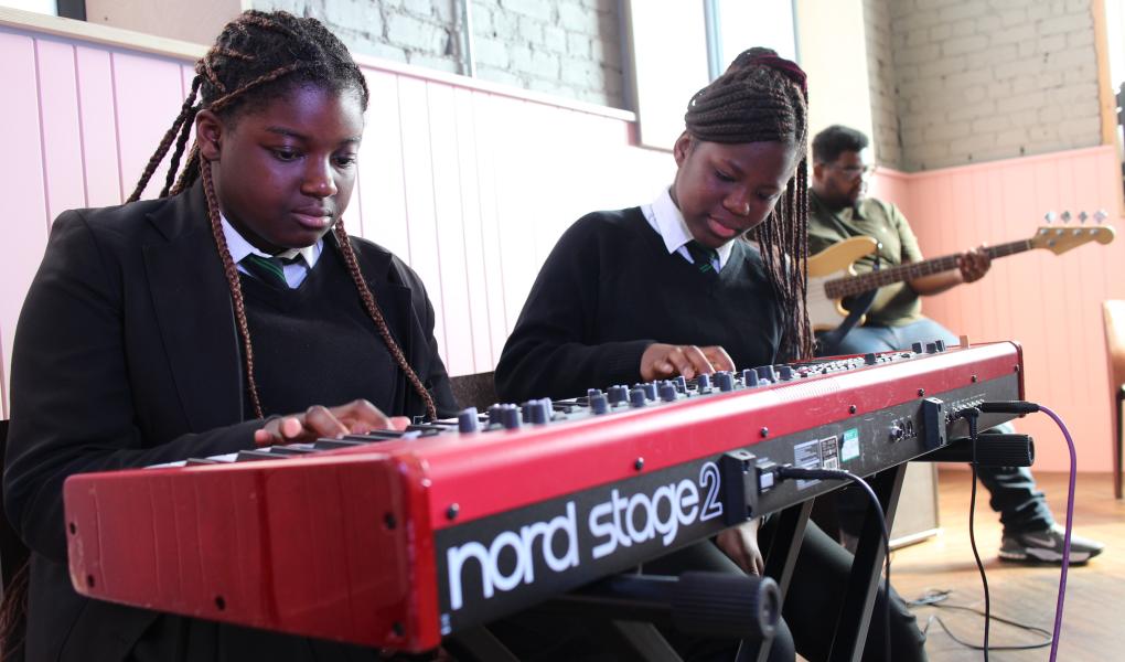 Two school pupils playing a Nord Stage 2 keyboard