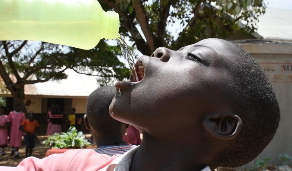 School pupil happily drinking water