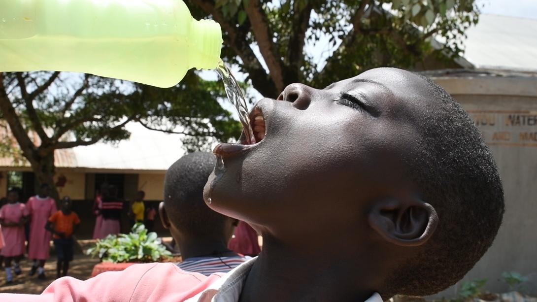 School pupil happily drinking water